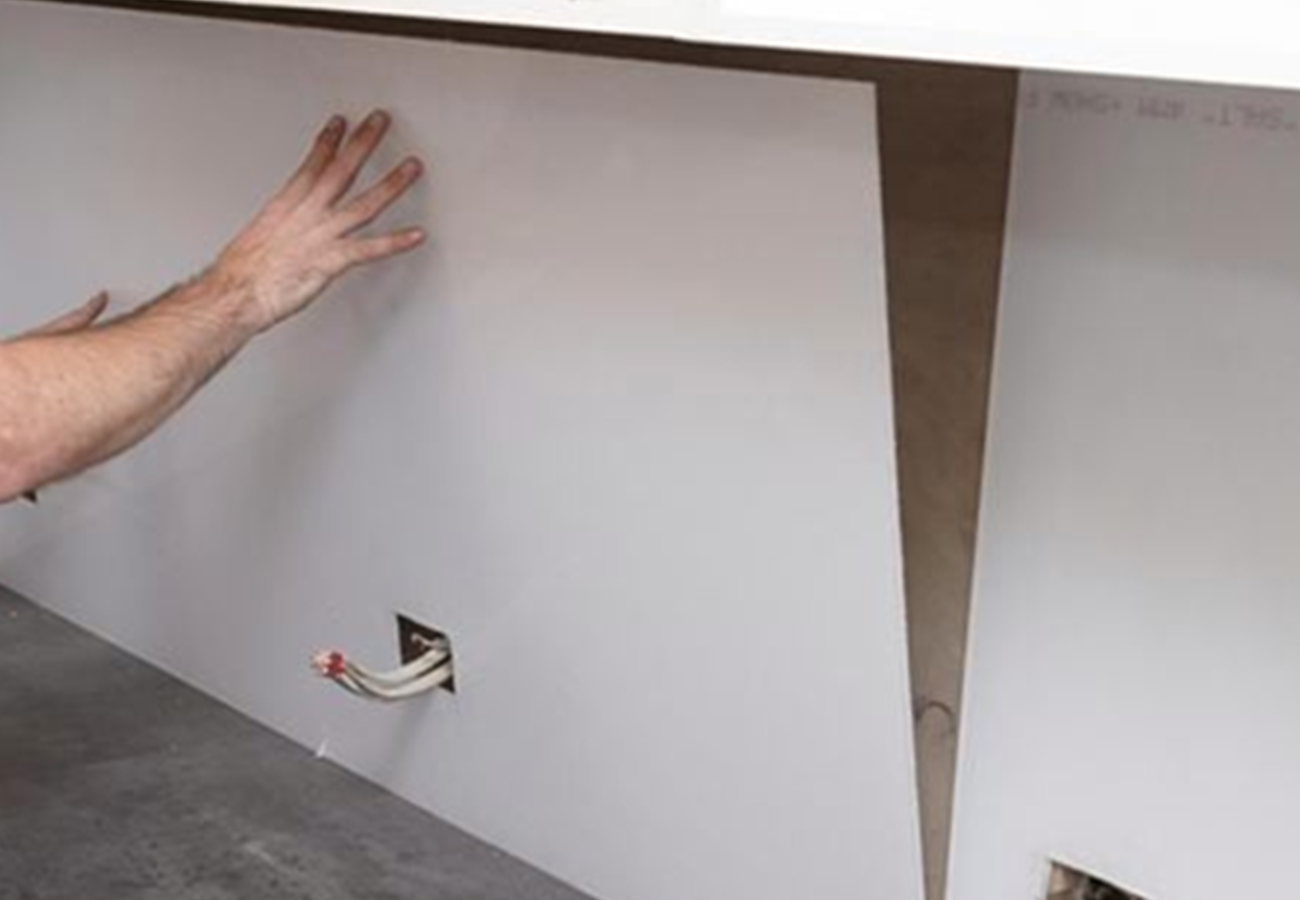 A professional installing a glass splashback