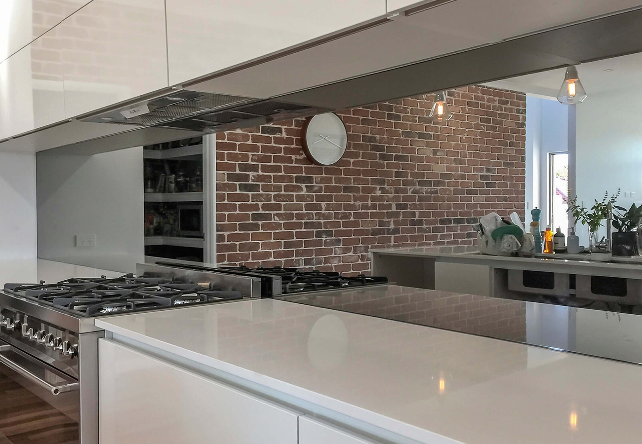 A modern kitchen with a mirrored splashback